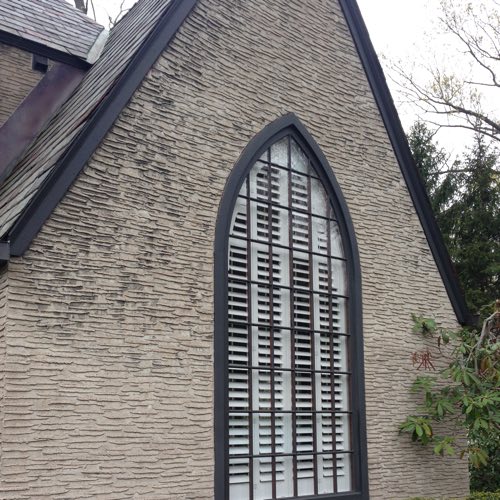 outdoor view of brick home with plantation shutters